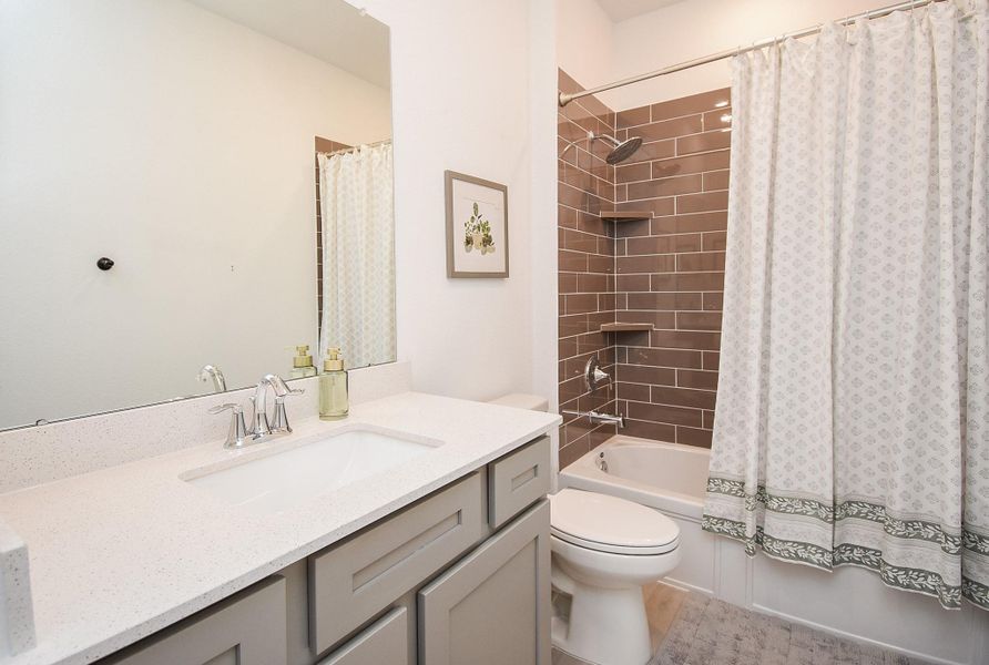 A well-appointed bathroom with a combination shower-tub and sleek fixtures.