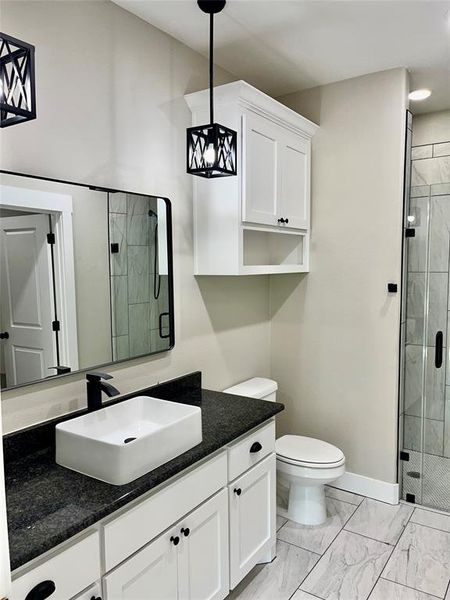 Bathroom with vanity, toilet, and an enclosed shower