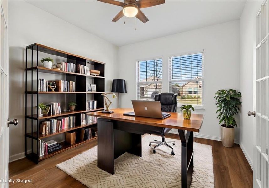 Office space with dark wood-type flooring and ceiling fan