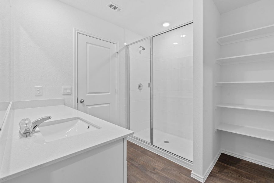 Bathroom with a shower stall, dark wood-style flooring, vanity, and recessed lighting Bathroom with a shower stall, dark wood-style flooring, vanity, and recessed lighting