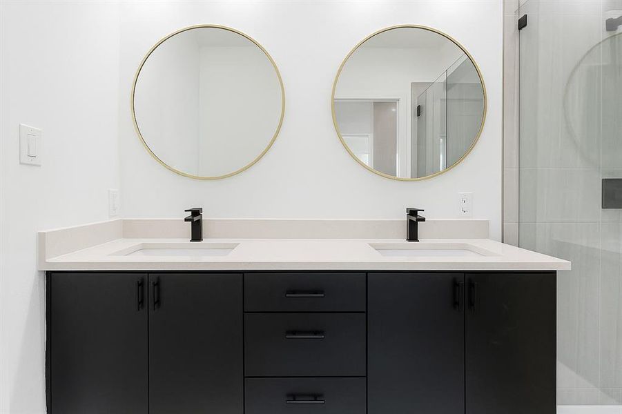 Full bathroom featuring double vanity and a shower with door