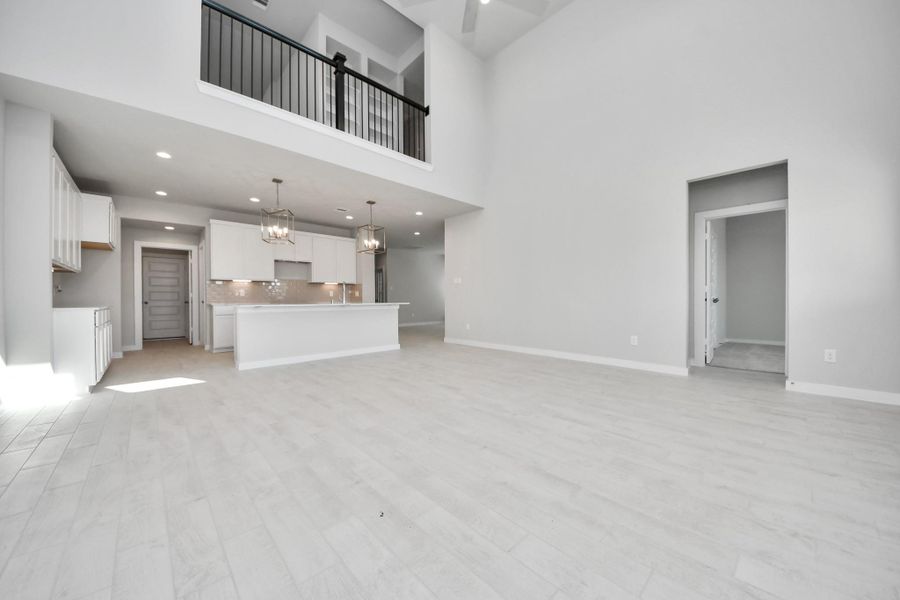 Gather the family and guests together in your lovely living room! Featuring soaring high ceilings, recessed lighting, ceiling fan, custom paint, gorgeous floors, and large windows that provide plenty of natural lighting throughout the day. Sample photo of completed home with similar floor plan. Actual colors and selections may vary. Gather the family and guests together in your lovely living room! Featuring soaring high ceilings, recessed lighting, ceiling fan, custom paint, gorgeous floors, and large windows that provide plenty of natural lighting throughout the day. Sample photo of completed home with similar floor plan. Actual colors and selections may vary.