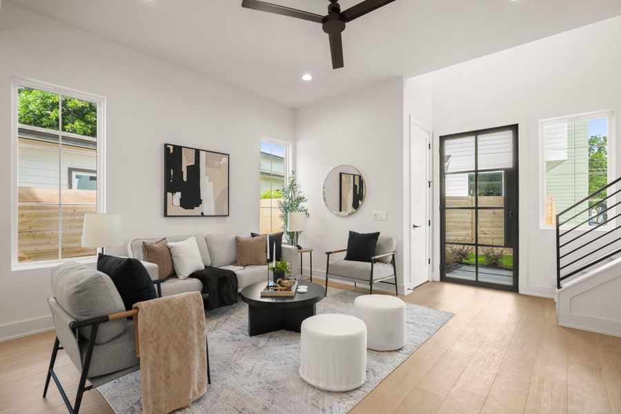 Natural light floods this inviting living space, highlighting modern design and gleaming hardwood flooring. Natural light floods this inviting living space, highlighting modern design and gleaming hardwood flooring.