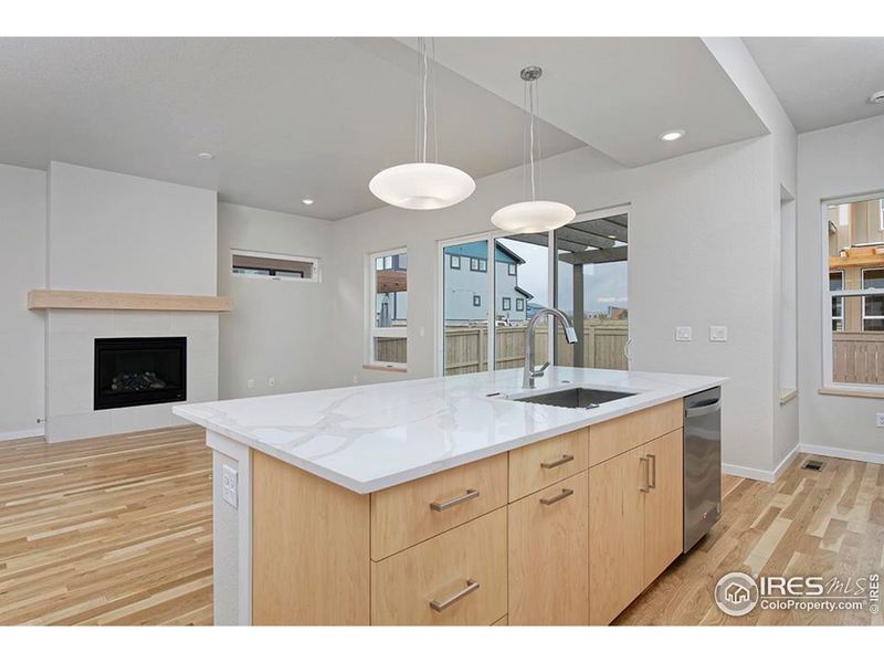 Quartz countertops, large island, natural maple accents.