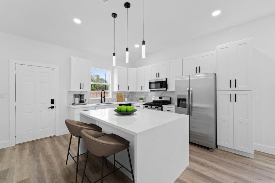 Virtually Staged: This gorgeous kitchen features a large island and breakfast bar, stainless steel appliances, an abundance of cabinetry and hardware, and a gorgeous tile backsplash!