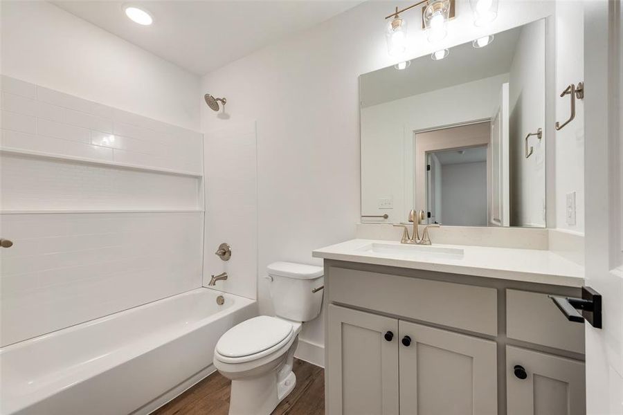 Full bathroom featuring vanity, toilet, bathing tub / shower combination, and wood-type flooring