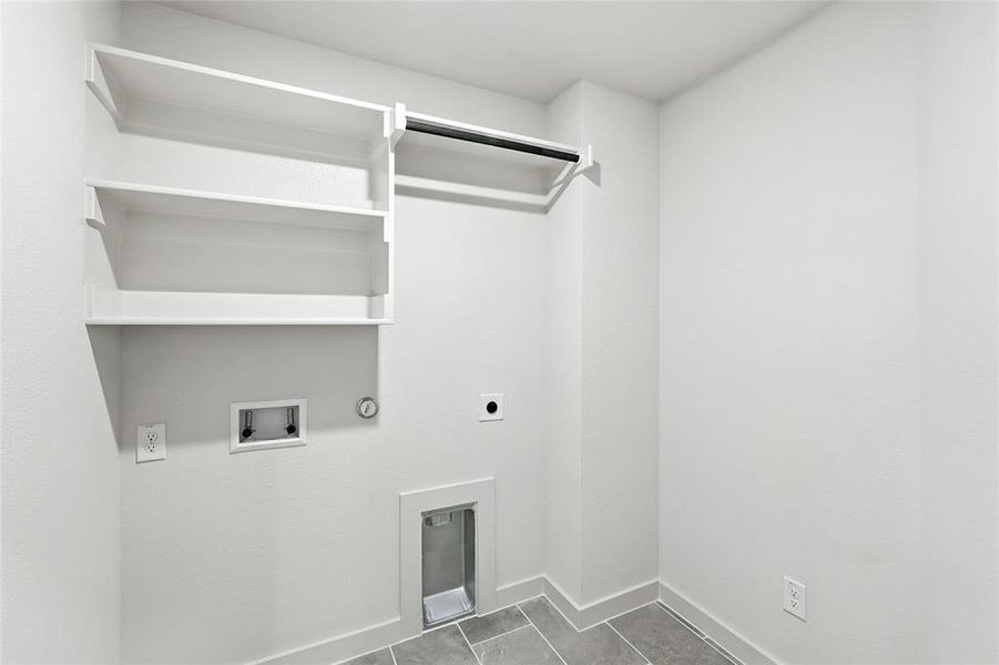 Laundry area featuring gas dryer hookup, electric dryer hookup, washer hookup, and dark tile patterned floors
