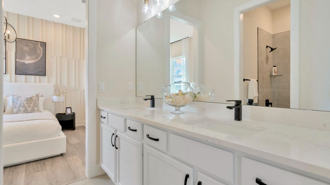 The Jack and Jill Bathroom of a DRB Homes Grand Eider model, which is a home plan offered at Serengeti in Spring Hill, FL.