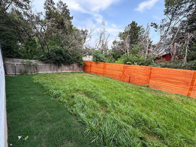 A spacious, fenced backyard offers a verdant lawn, ideal for outdoor activities. A spacious, fenced backyard offers a verdant lawn, ideal for outdoor activities.