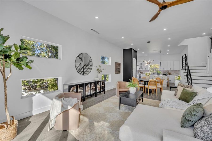 Living room with light wood-type flooring, plenty of natural light, and ceiling fan