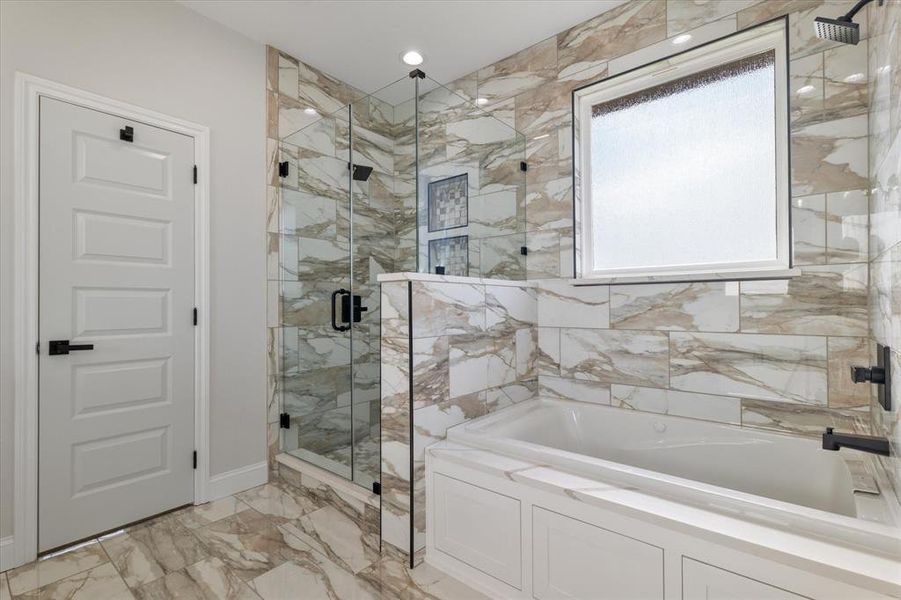 Bathroom with marble finish floor, a stall shower, and a bath