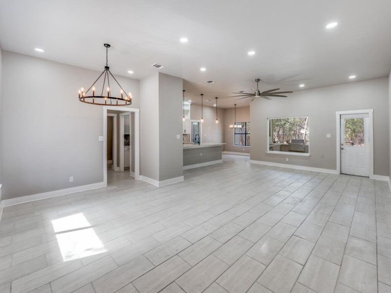 Unfurnished living room with a chandelier and a ceiling fan