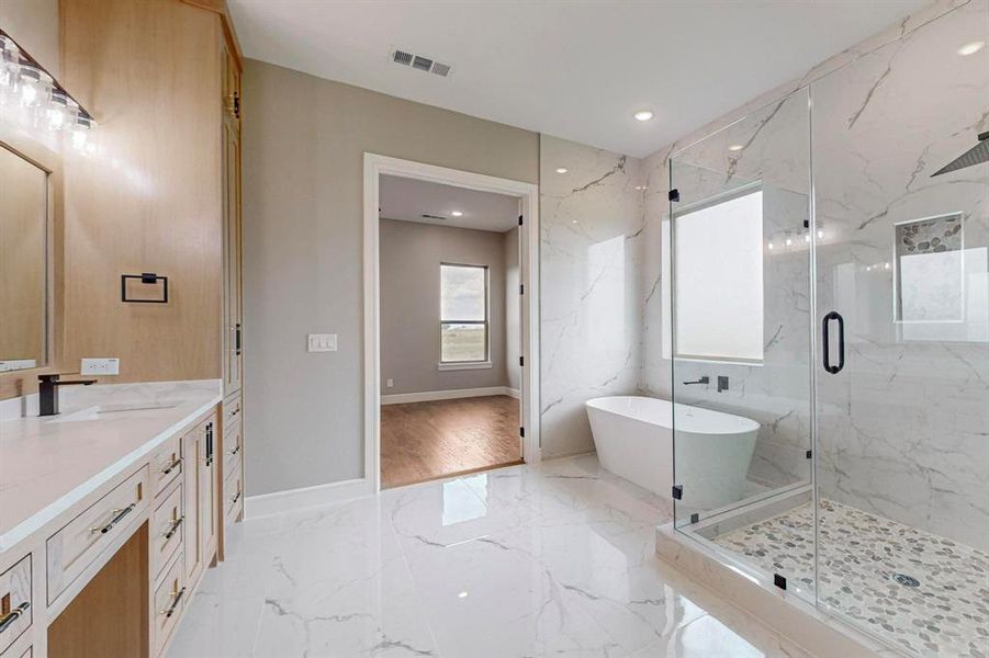 Bathroom featuring shower with separate bathtub and vanity