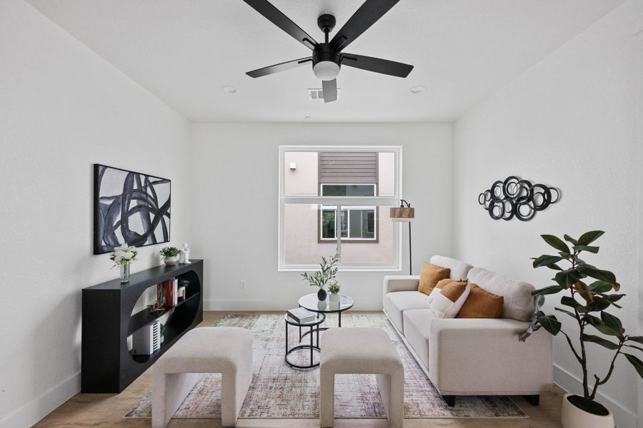Bright living space featuring a black ceiling fan, recessed lighting, wood-finish flooring, a large window, and crisp white walls