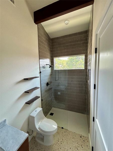 Full bathroom with walk in shower, vanity, speckle patterned floor, and beam ceiling Full bathroom with walk in shower, vanity, speckle patterned floor, and beam ceiling