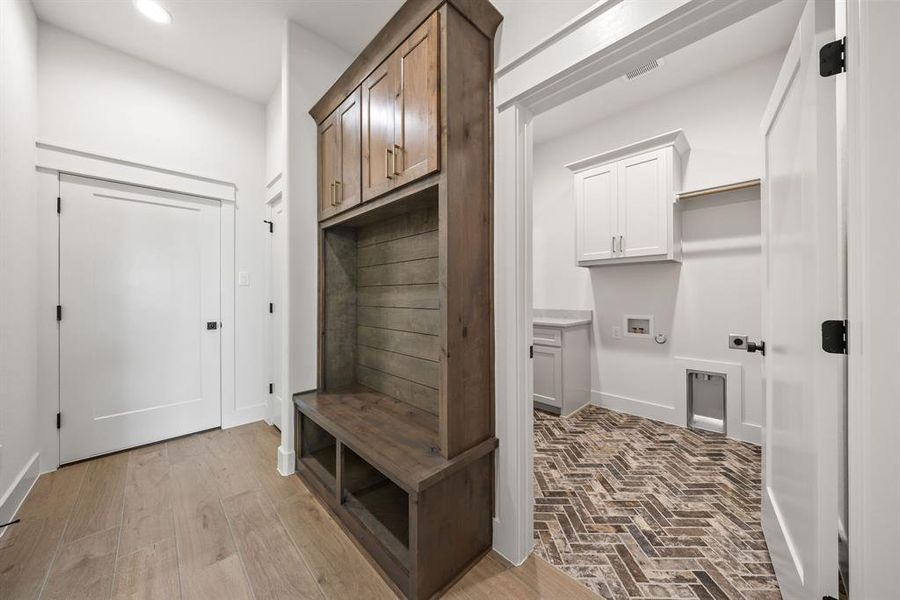 Built-in wood-finish mudroom cabinetry with bench seating and storage