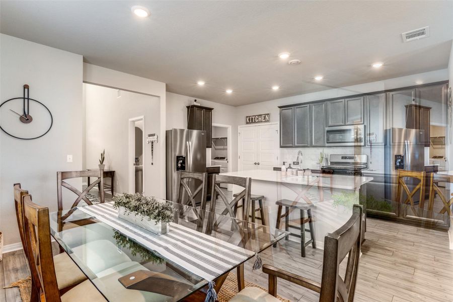 Dining space with light wood-style floors and recessed lighting