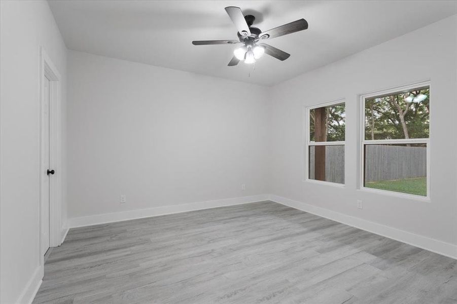 Unfurnished room with light hardwood / wood-style floors and ceiling fan