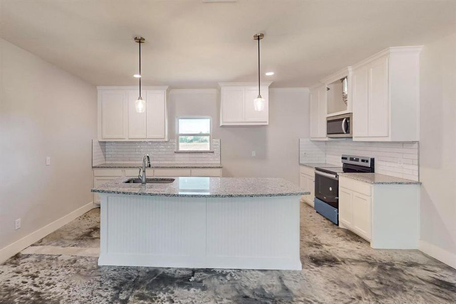 Kitchen with light stone countertops, appliances with stainless steel finishes, sink, white cabinets, and hanging light fixtures