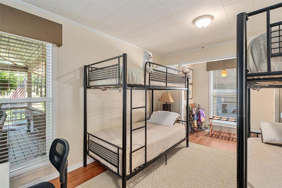 Room featuring wood-finish flooring, a neutral color palette, and white horizontal blinds