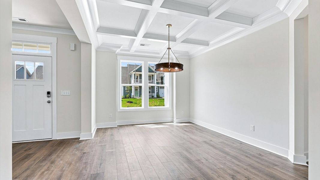 First-class dining area featuring a coffered ceiling and thoughtful architectural detail