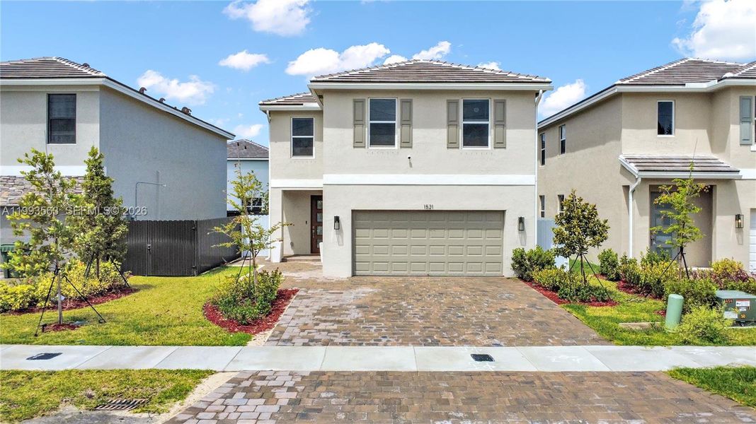 Front exterior of a new home in Messina Place, Homestead, FL, highlighting curb appeal (Image 2). Front exterior of a new home in Messina Place, Homestead, FL, highlighting curb appeal (Image 2).