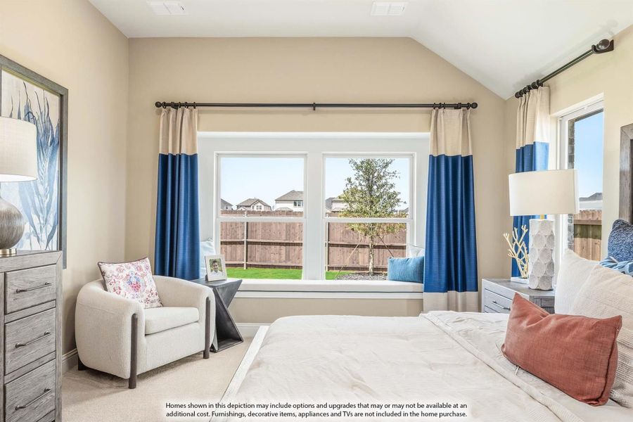 Bedroom with vaulted ceiling, window seat, blue curtains, and sitting area with accent chair