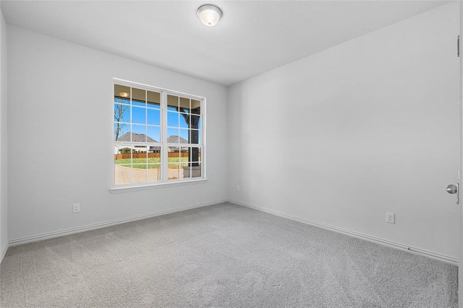 Empty room featuring light colored carpet and baseboards Empty room featuring light colored carpet and baseboards