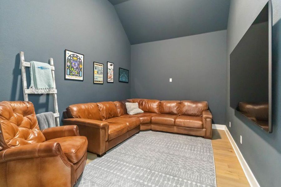 Step into a comfortable media room, where vaulted ceilings enhance the open feel for relaxed entertainment.
