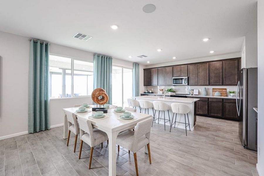 A kitchen with a dining table and chairs. A kitchen with a dining table and chairs.