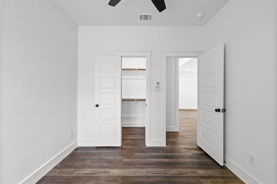 Unfurnished bedroom with dark wood-type flooring, ceiling fan, and a closet