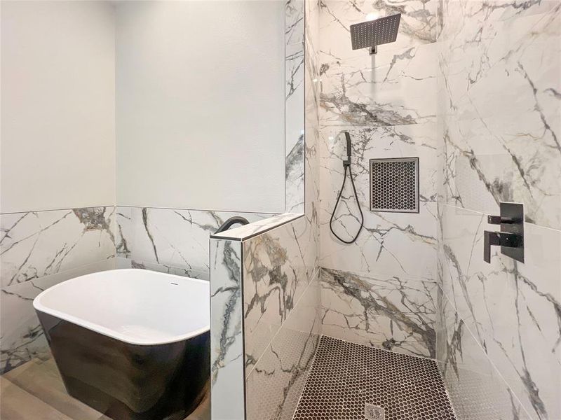 Full bath featuring a soaking tub, tile walls, and a marble finish shower Full bath featuring a soaking tub, tile walls, and a marble finish shower