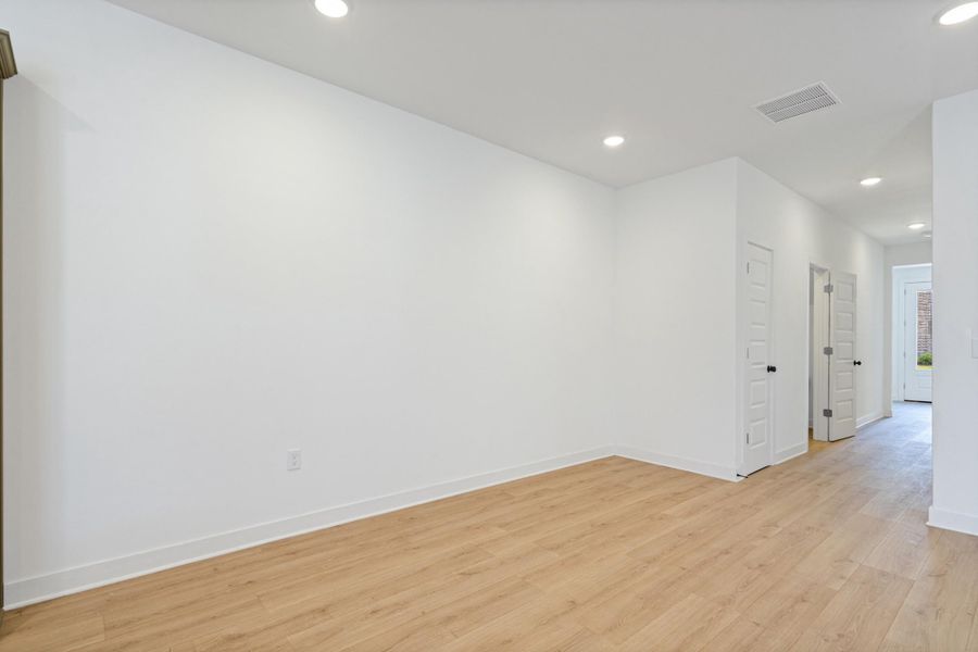 Bright interior space featuring light wood-finish flooring, recessed lighting, and white baseboards Bright interior space featuring light wood-finish flooring, recessed lighting, and white baseboards
