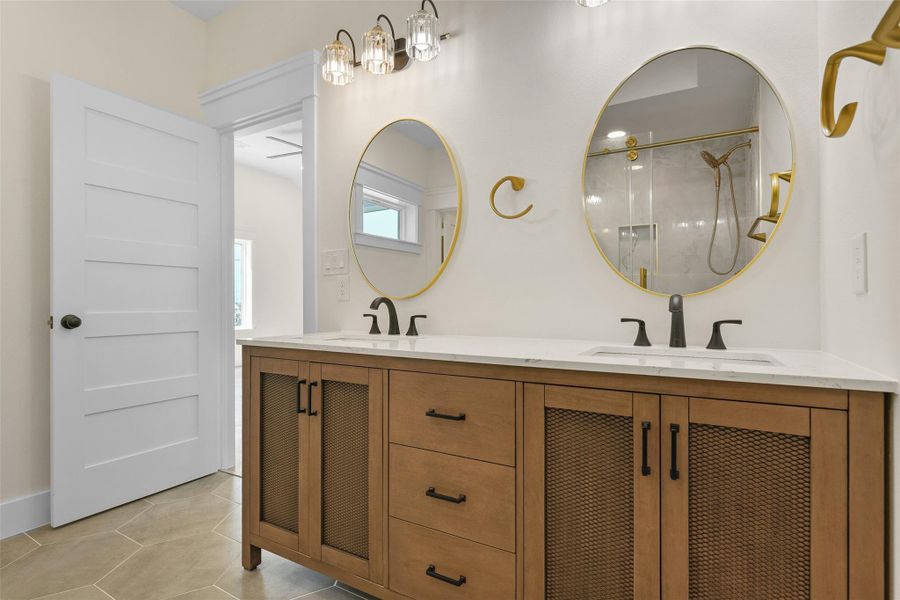 The primary ensuite has a modern and coastal vibe. It features a double vanity with stylish gold-trimmed mirrors, elegant lighting fixtures, and a neutral color scheme. The primary ensuite has a modern and coastal vibe. It features a double vanity with stylish gold-trimmed mirrors, elegant lighting fixtures, and a neutral color scheme.