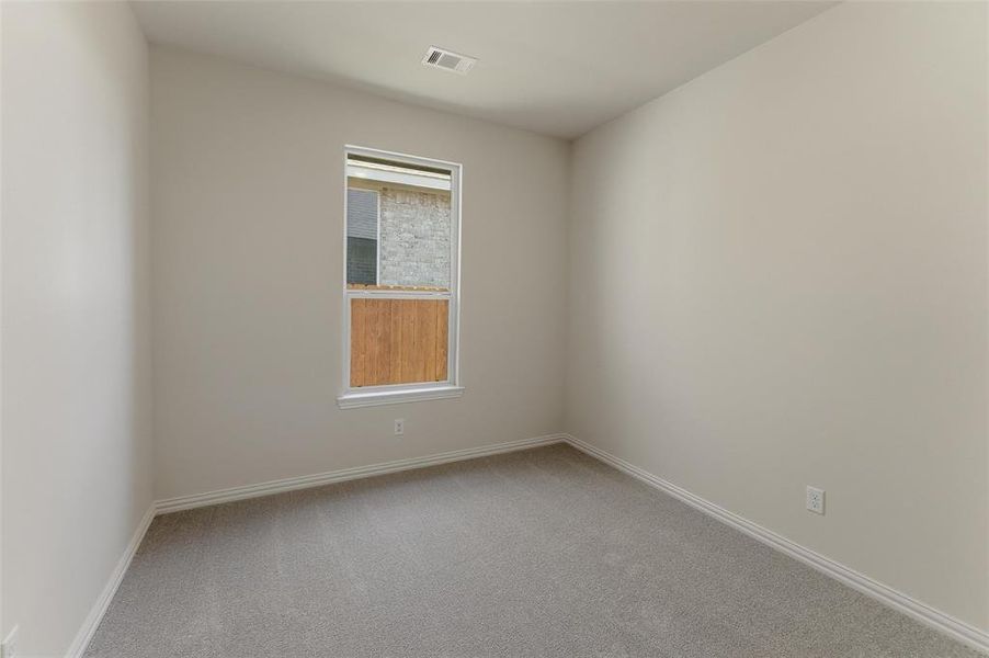 Neutral-toned room with light gray carpeting and white baseboards