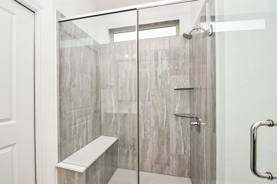 Luxury primary bathroom with large shower and bench