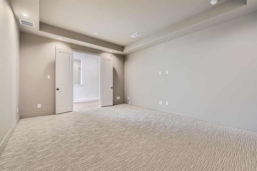 Carpeted empty room with a tray ceiling