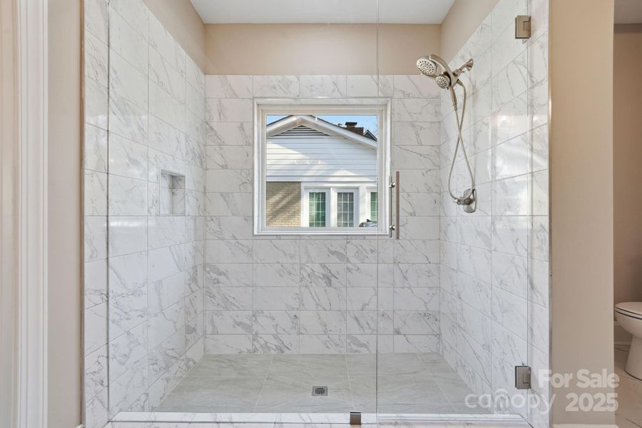 Walk-in shower with seamless glass enclosure and upscale tile work. Walk-in shower with seamless glass enclosure and upscale tile work.
