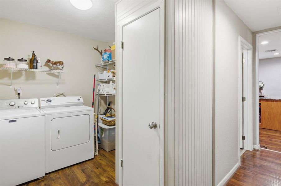 Dedicated utility area featuring wood-finish flooring, overhead wire shelving, and neutral wall tones