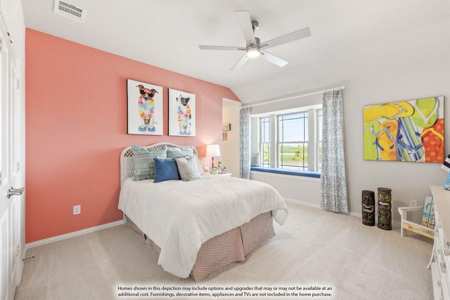 Bedroom with coral accent wall, ceiling fan, carpet floors, and window seat with natural light