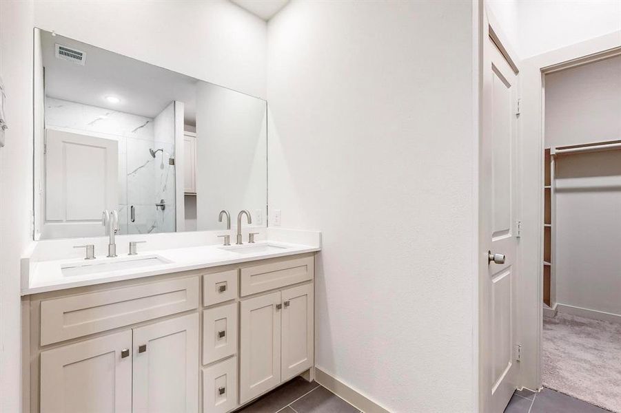 Bathroom with vanity, an enclosed shower, and tile patterned floors