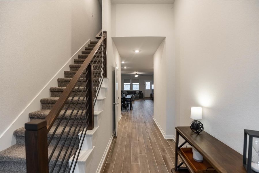 Staircase featuring wood finish floors, a ceiling fan, and recessed lighting Staircase featuring wood finish floors, a ceiling fan, and recessed lighting