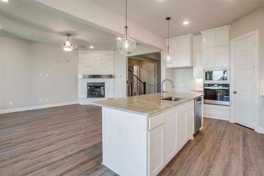 Kitchen featuring appliances with stainless steel finishes, white cabinetry, a kitchen island with sink, and sink