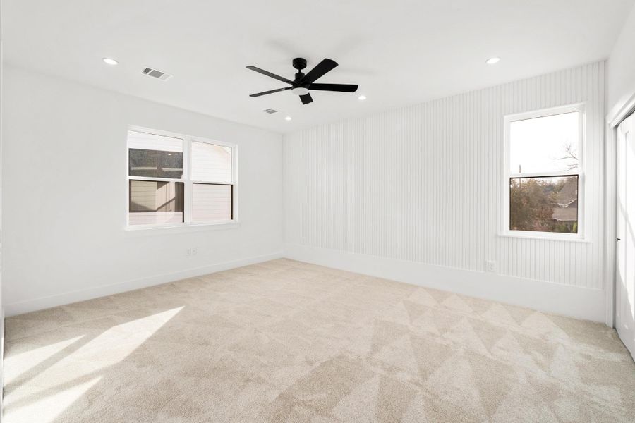 Unfurnished room featuring light colored carpet, healthy amount of natural light, a ceiling fan, and recessed lighting