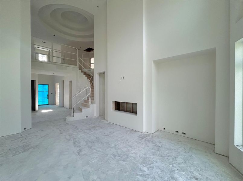 Living Area That Features High Ceilings, Natural Light, and An Electric Fireplace. Construction Photo as of  5/20/2026