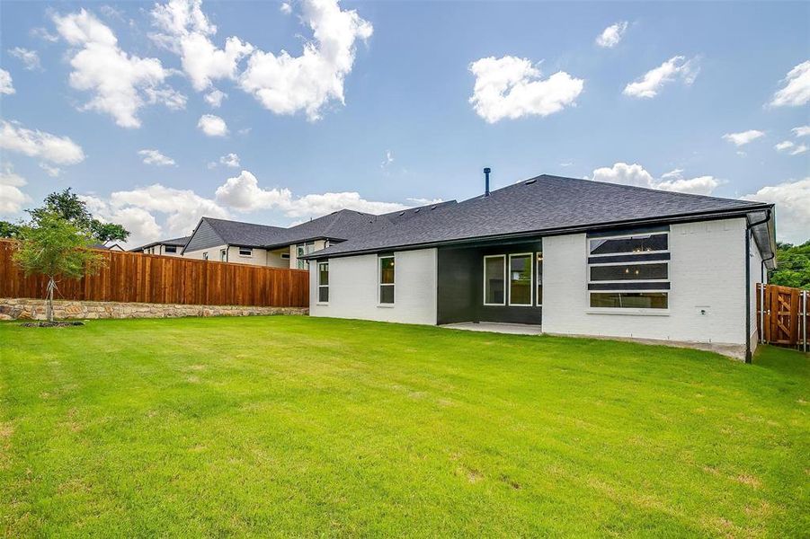 Rear view of house featuring a patio area and a lawn