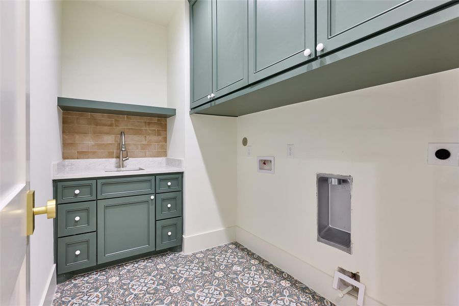 The utility room showcases built-in cabinetry in a soft green hue, offering both style and functionality. The utility room showcases built-in cabinetry in a soft green hue, offering both style and functionality.