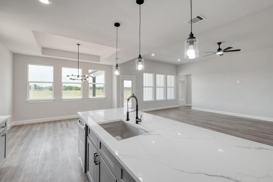 Kitchen featuring a sink, light wood-type flooring, plenty of natural light, baseboards, and recessed lighting