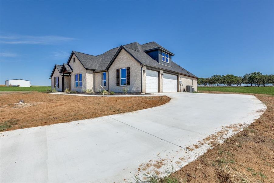 View of front of home featuring cooling unit and a garage