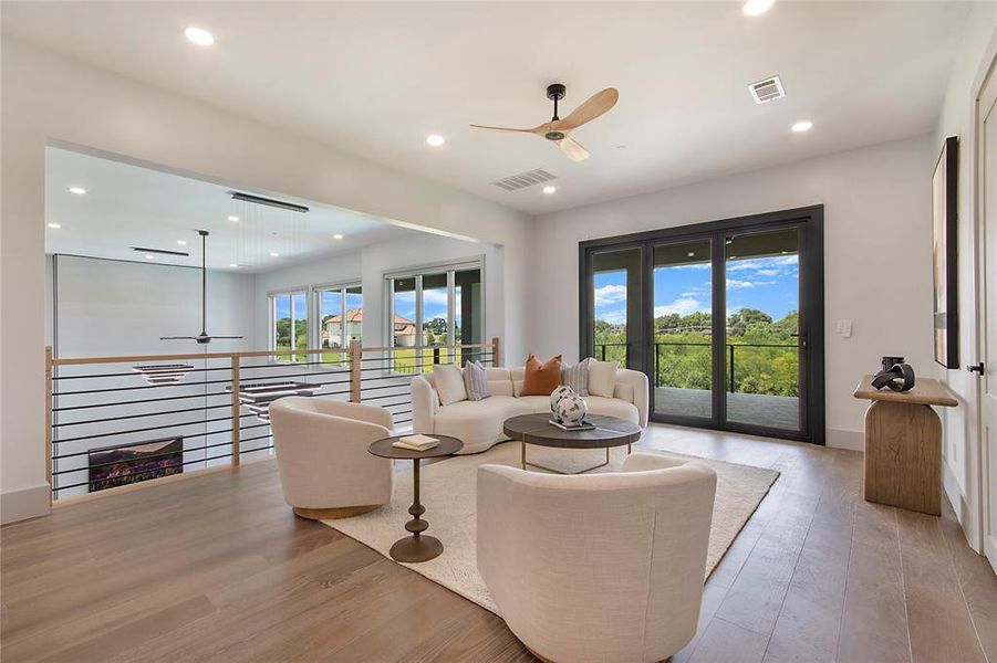 Living room featuring a ceiling fan, light wood-style floors, and recessed lighting